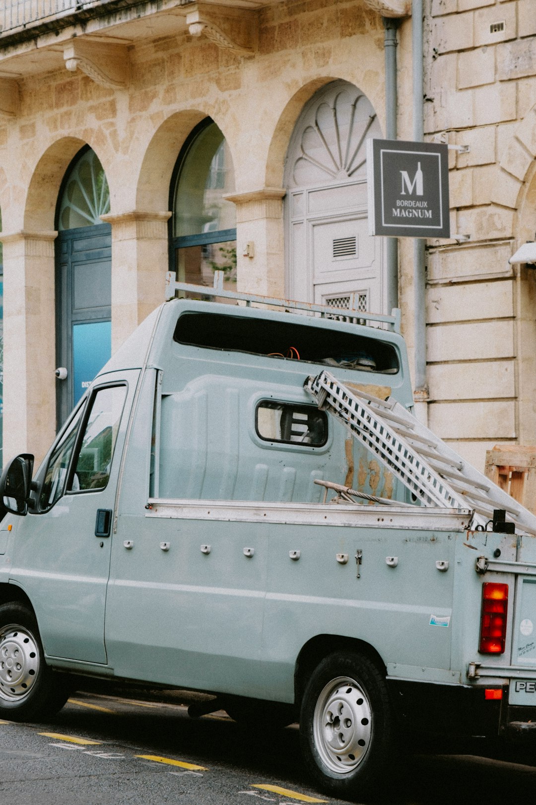 a-blue-van-parked-in-front-of-a-building-bt2gxsc4pkg